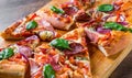 Pizza with Mozzarella cheese, ham, tomato sauce, salami, onion, pepper, Spices and Fresh basil. Italian pizza on wooden table Royalty Free Stock Photo