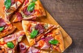 Pizza with Mozzarella cheese, ham, tomato sauce, salami, onion, pepper, Spices and Fresh basil. Italian pizza on wooden table Royalty Free Stock Photo