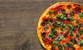 Pizza with Mozzarella cheese, salami, pepper, pepperoni, Tomatoes, olives, Spices and Fresh Basil. Italian pizza on wooden backgro Royalty Free Stock Photo