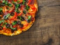 Pizza with Mozzarella cheese, salami, pepper, pepperoni, Tomatoes, olives, Spices and Fresh Basil. Italian pizza on wooden backgro Royalty Free Stock Photo