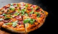 Pizza with Mozzarella cheese, salami, Tomato sauce, pepper, Spices and Fresh arugula. Italian pizza on Dark grey black slate backg Royalty Free Stock Photo