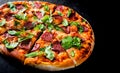 Pizza with Mozzarella cheese, salami, Tomato sauce, pepper, Spices and Fresh arugula. Italian pizza on Dark grey black slate backg Royalty Free Stock Photo