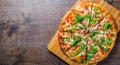 Pizza with Mozzarella cheese, salmon fish, tomato sauce, pepper. Italian pizza on wooden table Royalty Free Stock Photo