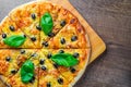 Pizza with Mozzarella cheese, Tomatoes, pepper, olive, Spices and Fresh Basil. Italian pizza. Pizza Margherita or Margarita on woo Royalty Free Stock Photo