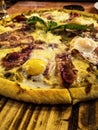 Pizza with mushrooms, bacon and egg on a restaurant plate Royalty Free Stock Photo