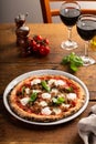 Pizza Napolitana or Naples style with mozzarella, basil and sausage