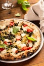 Pizza Napolitana or Naples style with mozzarella, mushrooms and spinach