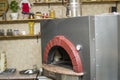 Pizza near the stone stove with fire. Background of a traditional pizzeria restaurant with a fire place