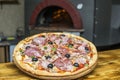 Pizza near the stone stove with fire. Background of a traditional pizzeria restaurant with a fire place