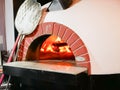 pizza oven. Cooking pizza in a traditional brick-fired wood oven. A brick pizza oven on a wooden stand is about to bake. Colorful Royalty Free Stock Photo