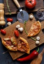 Pizza party over concept. Vegetarian pizzas leftovers and raw mushrooms, bell peppers and tomatoes on oak boards Royalty Free Stock Photo