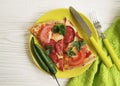 Pizza piece portion sausage fork pepper knife tomato on white wooden Royalty Free Stock Photo