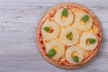 Pizza with pineapple rings and basil on the table Royalty Free Stock Photo