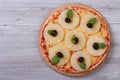 Pizza with pineapple rings, olives and basil on the table Royalty Free Stock Photo