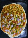 Pizza pre preparation getting ready to get into the oven with delicious toppings spread Royalty Free Stock Photo