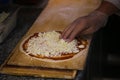 Pizza preperation. Adding cheese on pizza Royalty Free Stock Photo