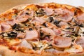 Pizza prosciutto e funghi, traditional italian oven baked: tomato sauce, mozzarella, ham, mushrooms