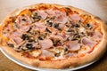 Pizza prosciutto e funghi, traditional italian oven baked: tomato sauce, mozzarella, ham, mushrooms