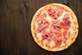 Pizza with prosciutto parma ham on dark wooden background top view