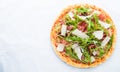 Pizza with prosciutto (parma ham), arugula (salad rocket) and parmesan on white background top view