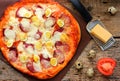 Pizza with quail eggs, sausage, cheese and tomatoes on a wooden Royalty Free Stock Photo