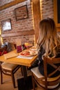 Pizza quattro stagioni with egg served in the restaurant. Woman sitting alone eating pizza in the restaurant Royalty Free Stock Photo