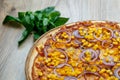 Pizza with red sauce, ham, mozarella, corn and onion rings detail