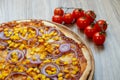 Pizza with red sauce, ham, mozarella, corn and onion rings detail