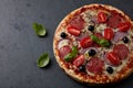 Pizza with salami, mozzarella cheese, cherry tomatoes, black olives, red onion and oregano. Royalty Free Stock Photo