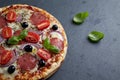 Pizza with salami, mozzarella cheese, cherry tomatoes, black olives, red onion and oregano. Home made food. Royalty Free Stock Photo