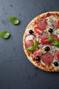 Pizza with salami, mozzarella cheese, cherry tomatoes, black olives, red onion and oregano. Royalty Free Stock Photo