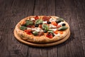 Pizza with salami, mozzarella, olives and basil on wooden table Royalty Free Stock Photo