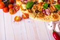 Pizza with Salami Vegetables and Spices on a white wooden background with copy space. Royalty Free Stock Photo