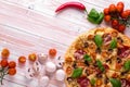 Pizza with Salami Vegetables and Spices on a white wooden background with copy space. Royalty Free Stock Photo