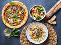 Pizza with salat and pasta ready to eat on a stone undergound