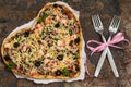 Pizza in the shape of a heart. Romantic dinner. Old table. Top view. Close-up