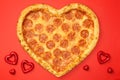 Pizza shaped heart flat lay with Valentine`s Day on red background