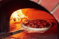 Pizza on the showel. Fire burning in the furnace. Close up view of wood in flames Royalty Free Stock Photo