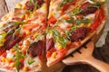 Pizza with shrimp, salami, cheese and arugula macro on a board. Royalty Free Stock Photo