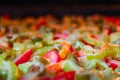 Pizza with sweet pepper, meat, vegetables, melted cheese, tomato and green olives. Selective focus, close-up. Royalty Free Stock Photo