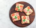 Pizza toast with sausage and tomatoes on a round wooden cutting board on a light gray background Royalty Free Stock Photo