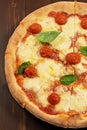 Pizza with tomato sauce, fresh mozzarella, Parmesan cheese and basil on wooden background Royalty Free Stock Photo