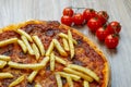 Pizza with tomato sauce, sausage and french fries detail