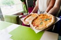 Pizza with tomatoes, mozzarella cheese, basil. Waiter with gloves takes out margarita pizza