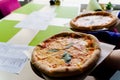 Pizza with tomatoes, mozzarella cheese, basil. Waiter with gloves takes out margarita pizza