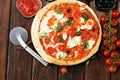 Pizza with tomatoes, mozzarella cheese, black olives and basil. Delicious italian pizza on wooden pizza board Royalty Free Stock Photo