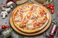 Pizza with tomatoes, mozzarella cheese, black olives and basil. Delicious italian pizza on wooden pizza board. Royalty Free Stock Photo