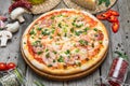 Pizza with tomatoes, mozzarella cheese, black olives and basil. Delicious italian pizza on wooden pizza board. Royalty Free Stock Photo