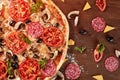 Pizza with tomatoes, mozzarella cheese, black olives and basil. Delicious italian pizza on wooden pizza board. Royalty Free Stock Photo