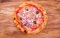 Pizza with tuna, onions and capers on a wooden dish, tray, background